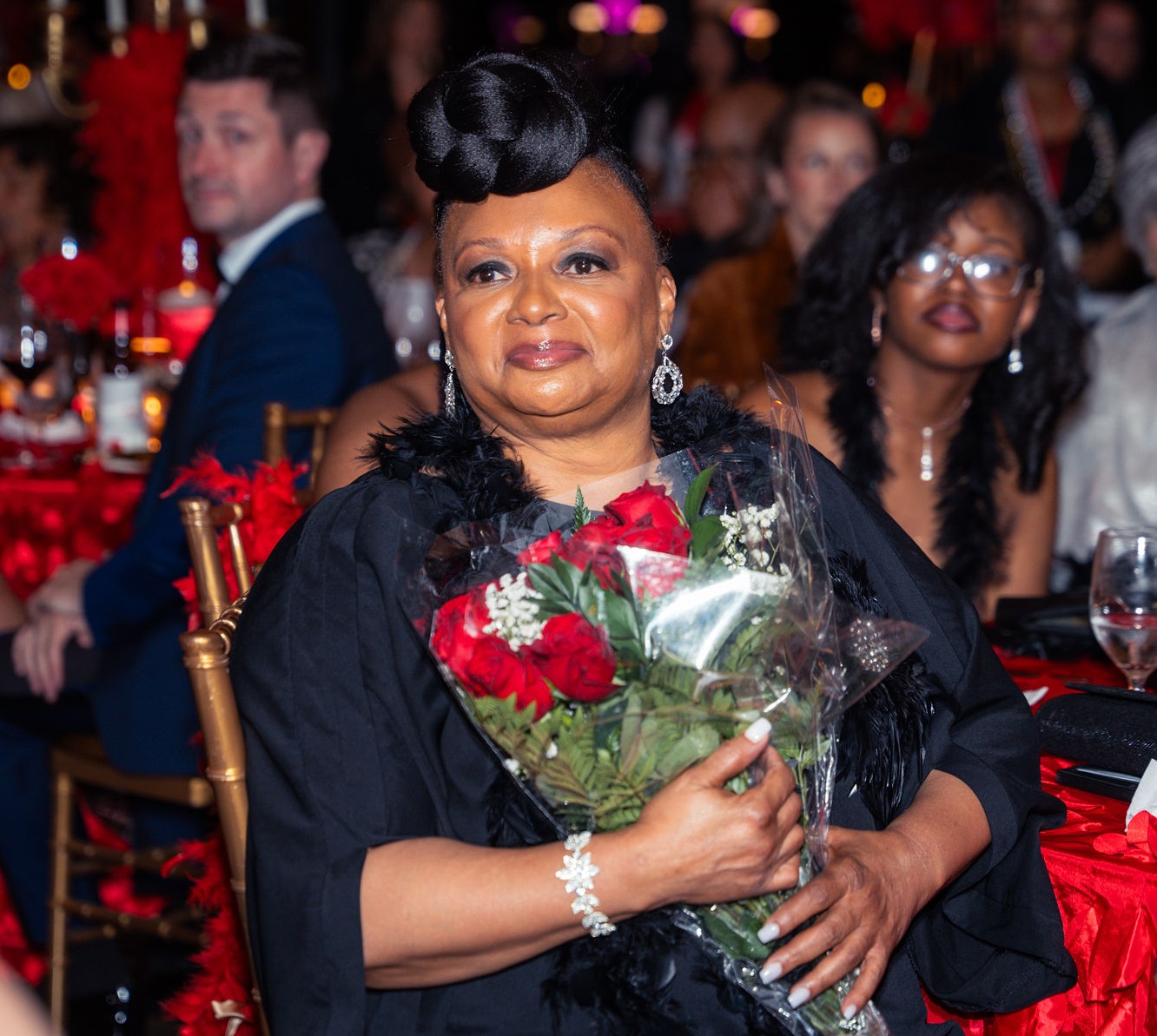 Woman holding bouquet of red roses.